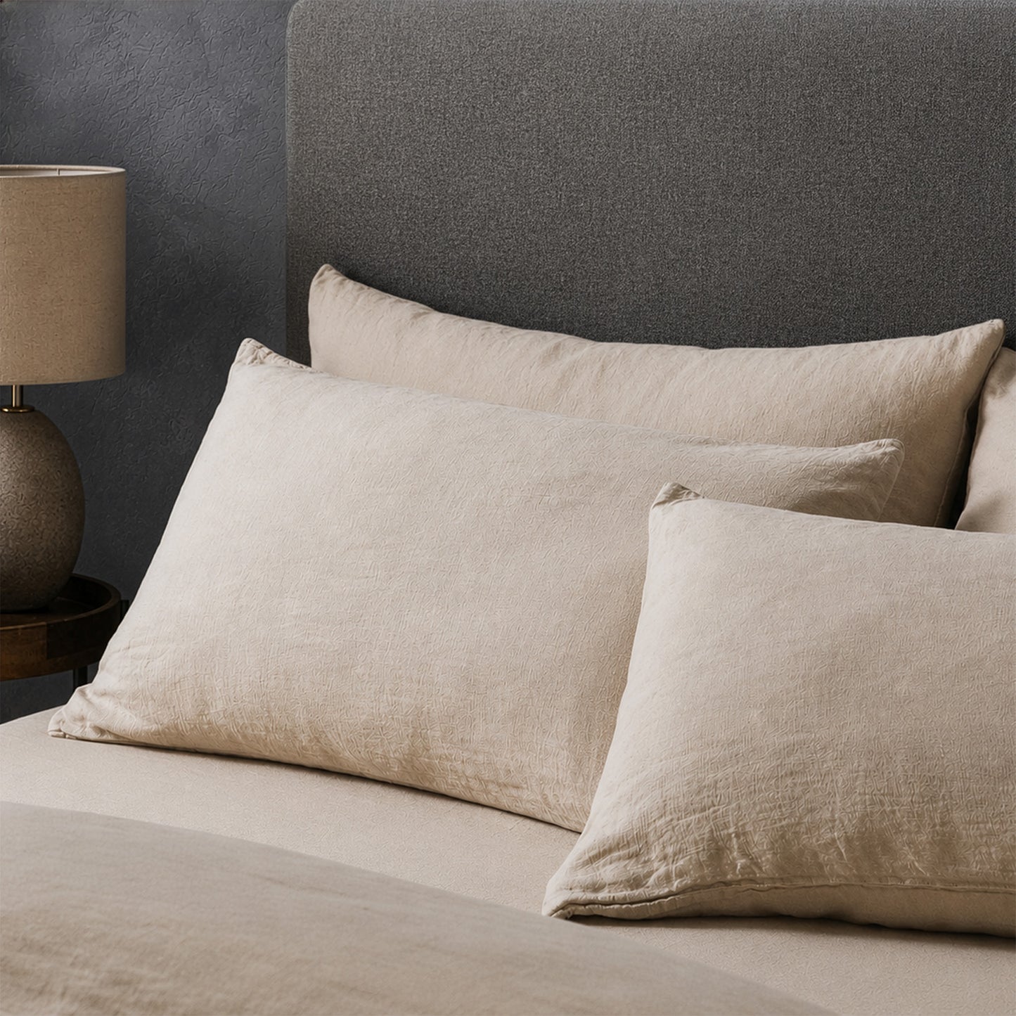 Four pillows on a dressed bed with the Mariana Linen Blend Pillow Cases in Sand.