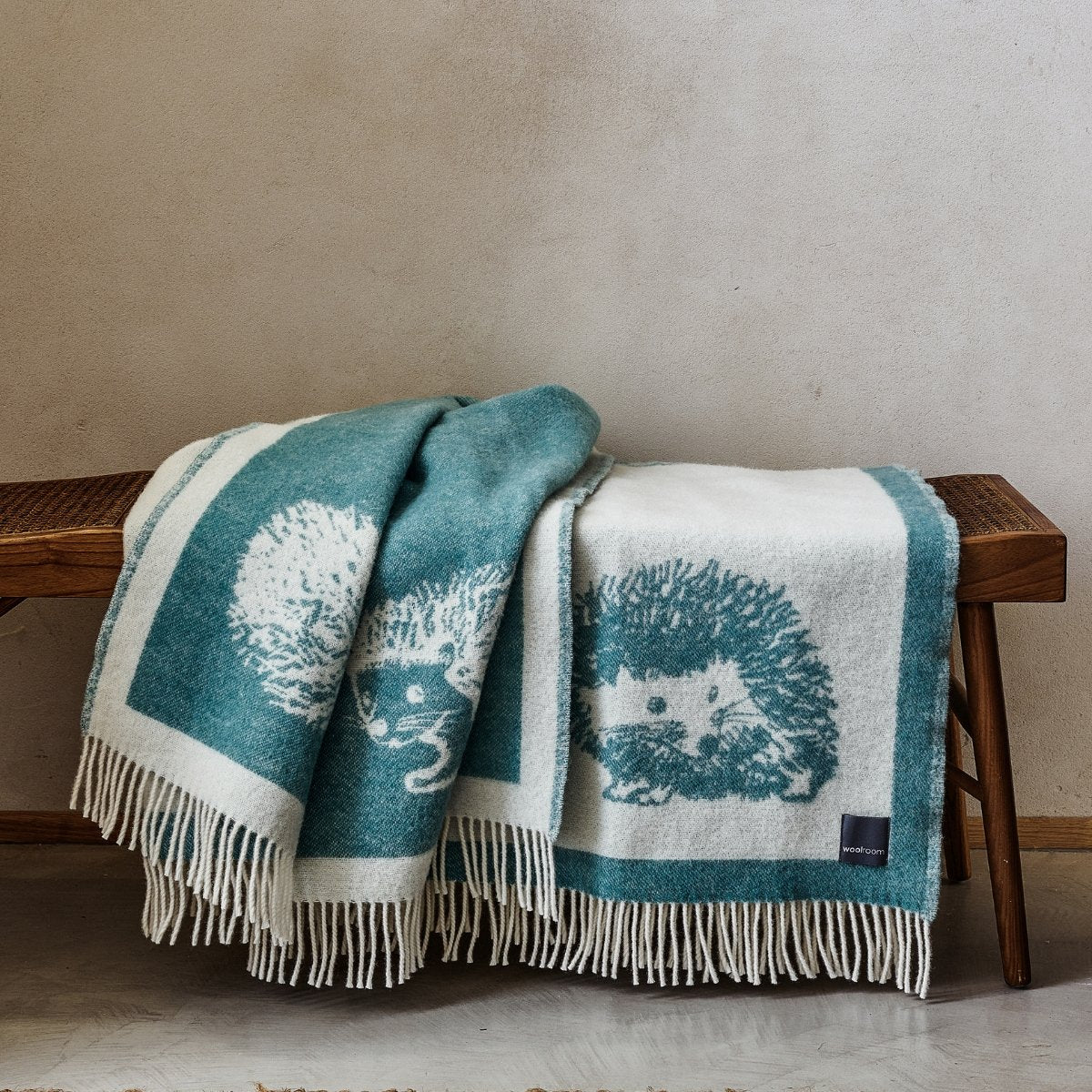 The playful Wild and Wool Hedgehog Wool Throw in Teal with white fringe belongs to the Woolroom animal throw collection.