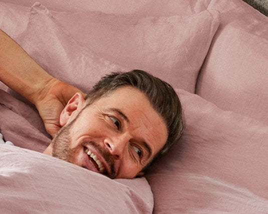 Man lying on a pink couch with a relaxed expression