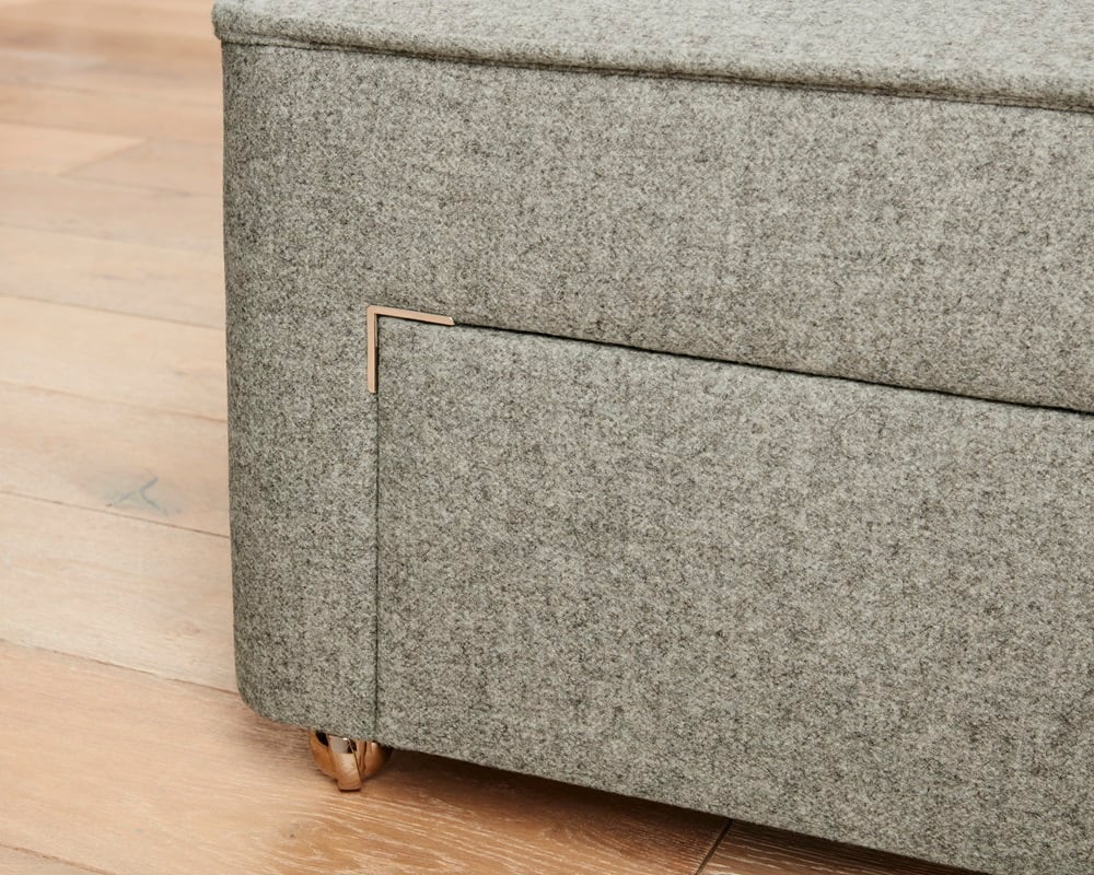 Gray textured storage ottoman on a wooden floor