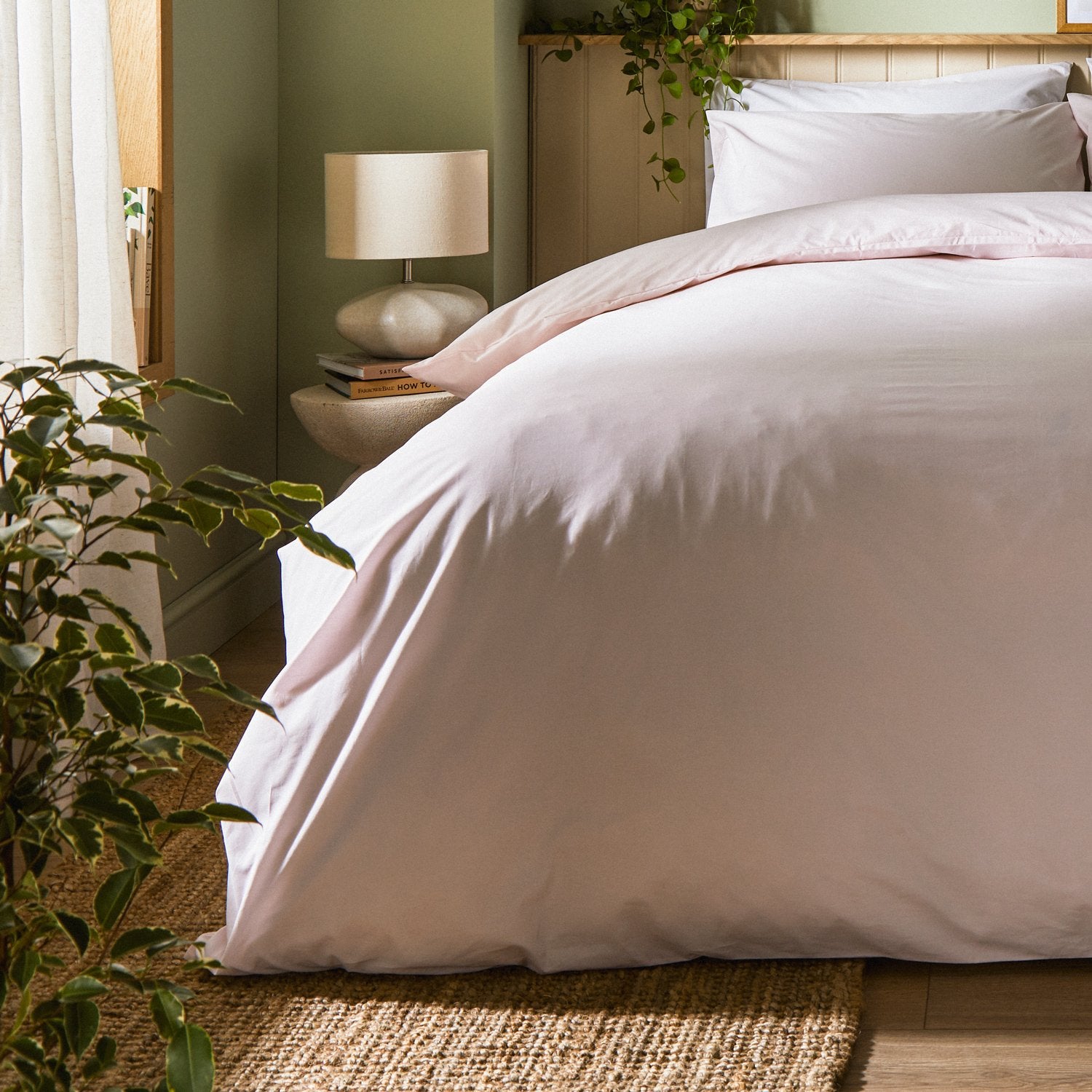 A dressed bed with Arinta Organic Cotton Comforter Cover in Marshmallow has the comforter turned down and two pillows.