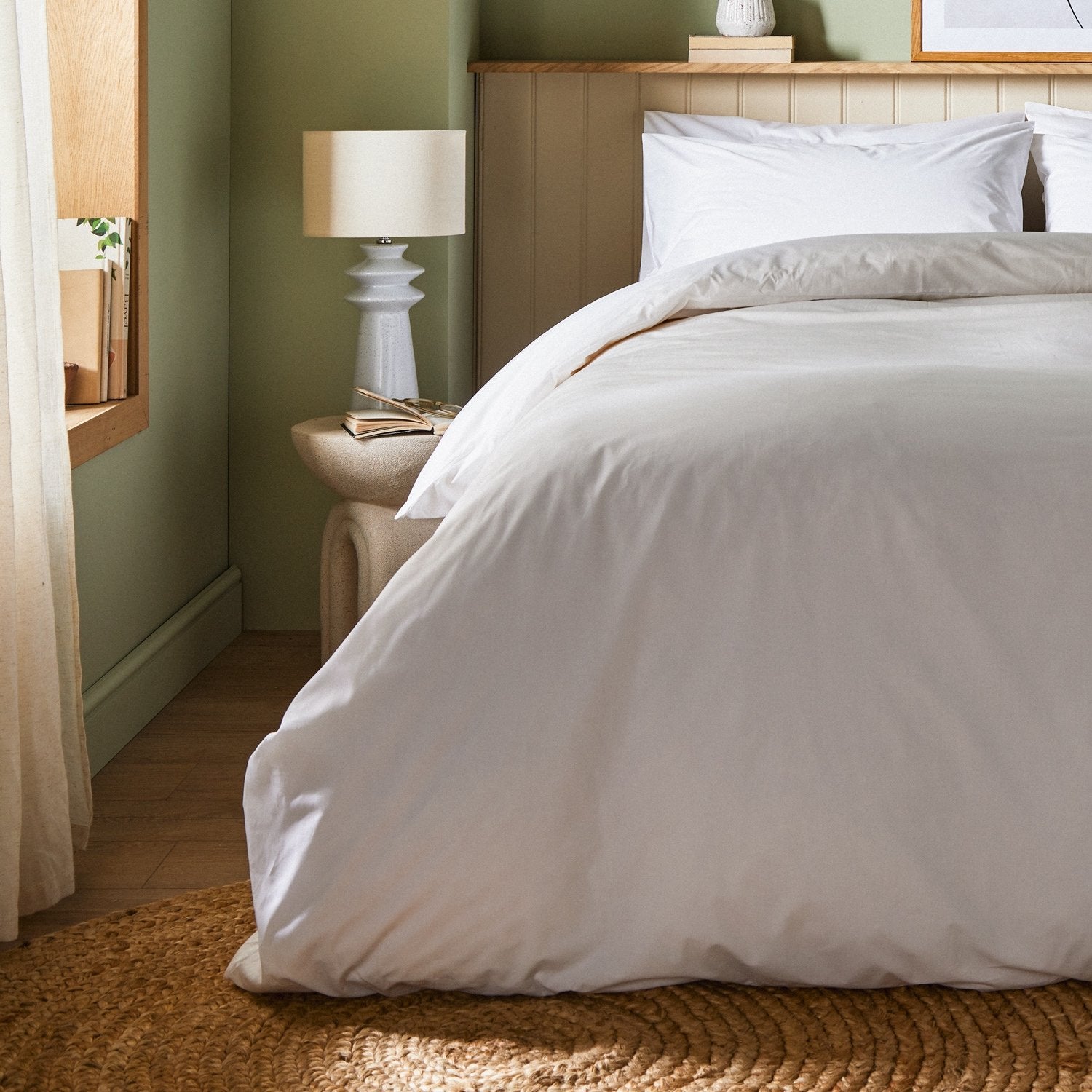 A dressed bed with Arinta Organic Cotton Comforter Cover in White has the comforter turned down and two pillows.