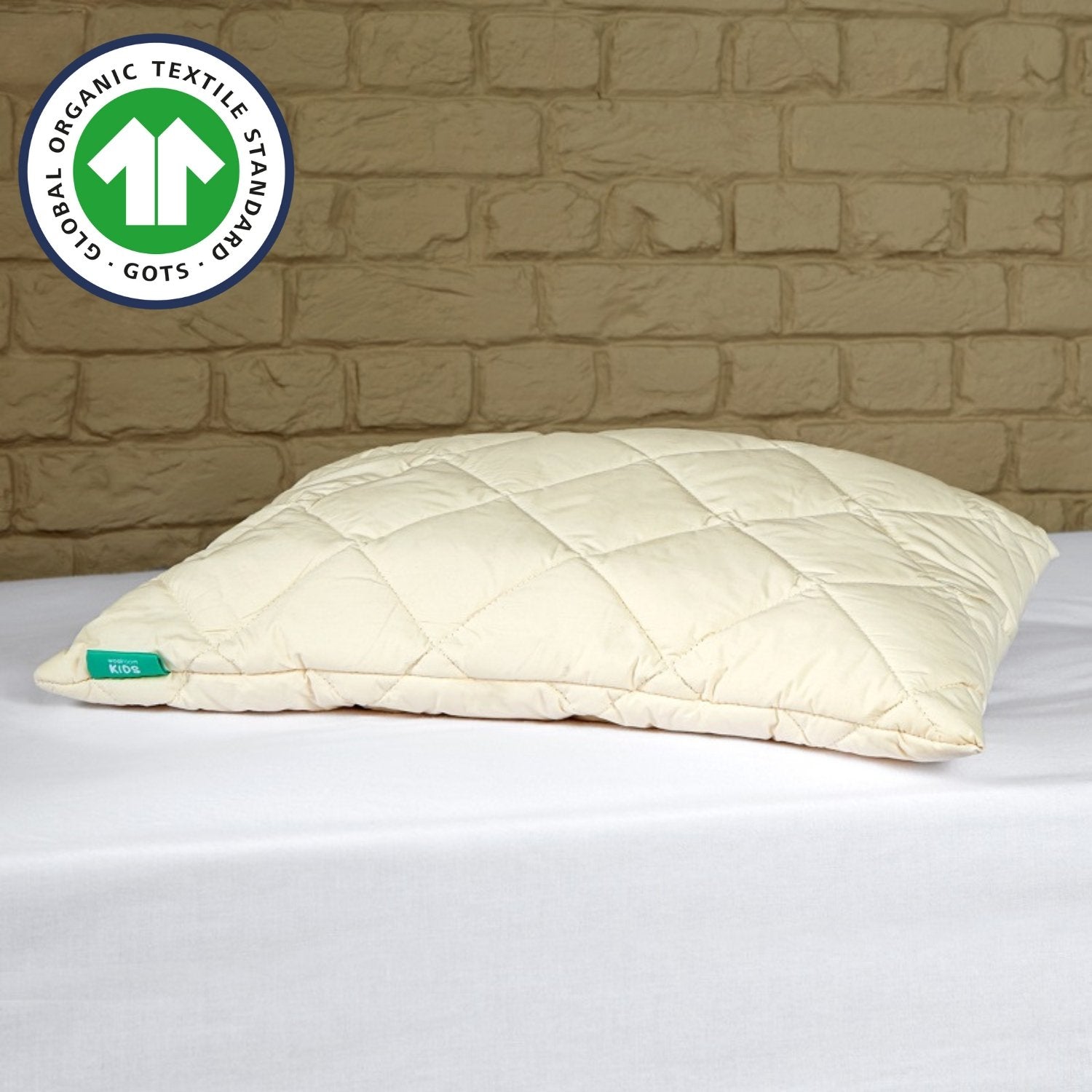 The Woolroom GOTS Organic Washable Wool Pillow in a kids size, on a Woolroom kids mattress with a white fitted sheet.