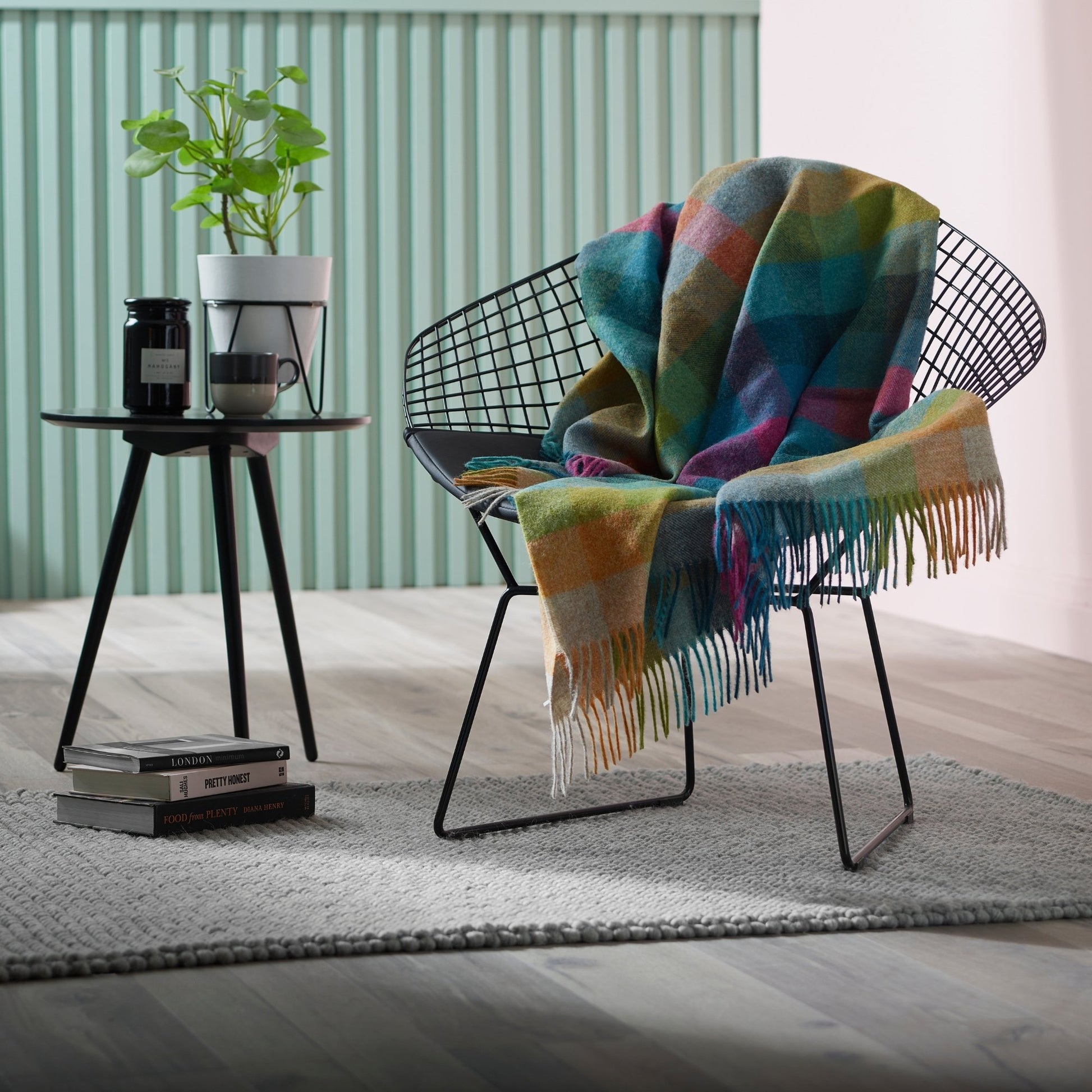 The Harlequin Shetland Throw in color Tutti Fruitti is a bright mix rainbow colors, draped in a chair with fringe.