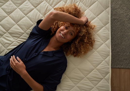 Woman lying on a mattress smiling