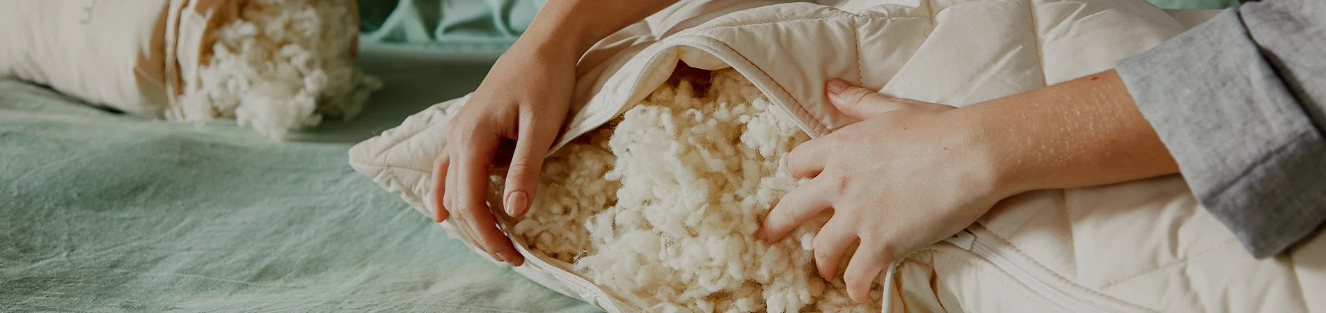 Person unpacking a pillow of wool on a textured surface