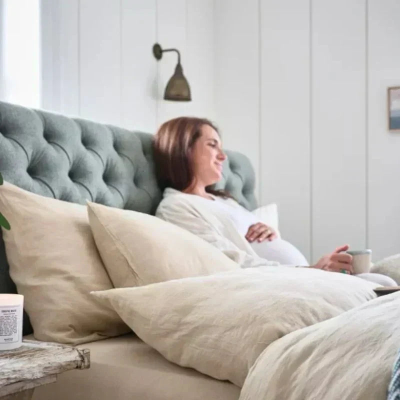 Pregnant lady drinking coffee in a woolroom bed