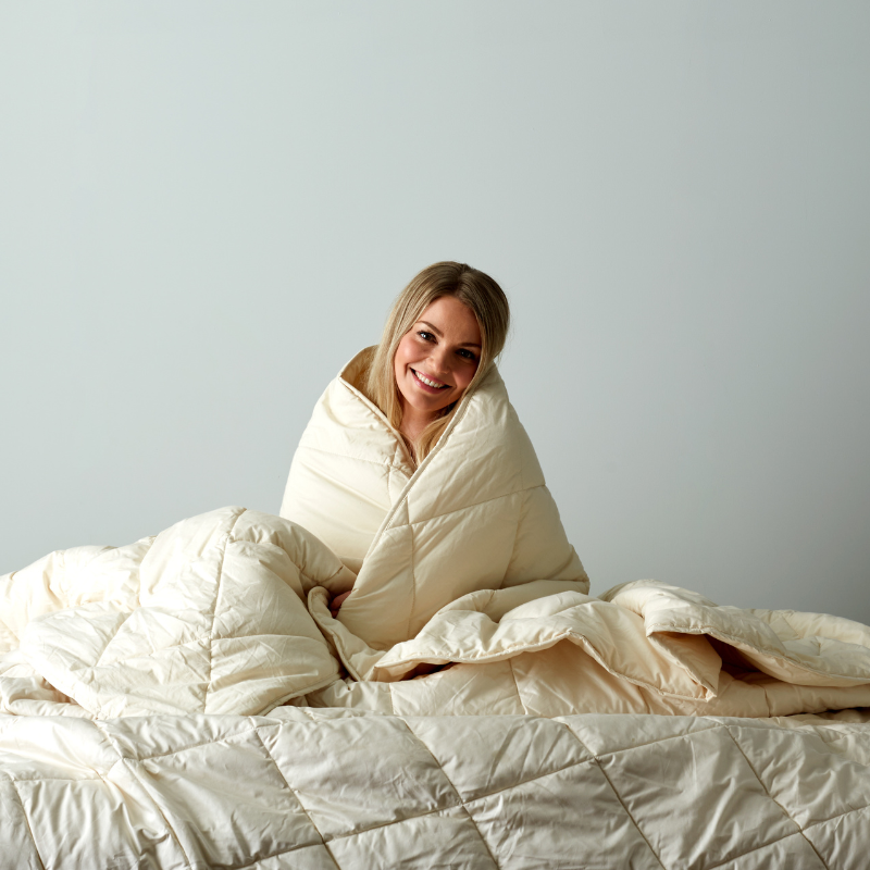 How to choose the best wool duvet for you - Women wrapped in Woolroom comforter