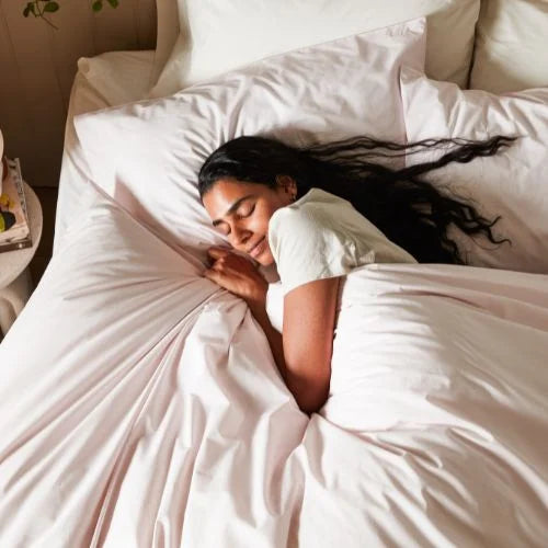 Girl ith long dark hair snuggled up in woolroom bedding