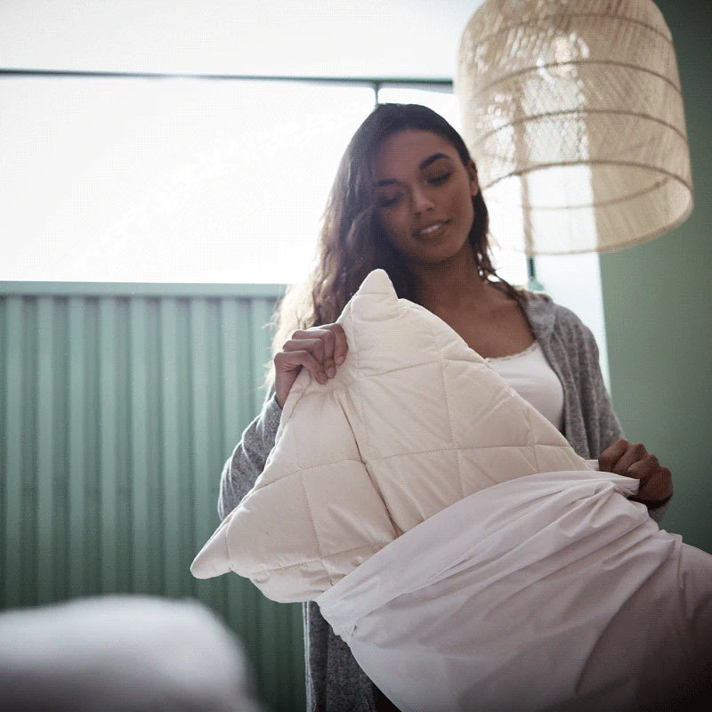 Lady removing a pillow out of a pillowcase