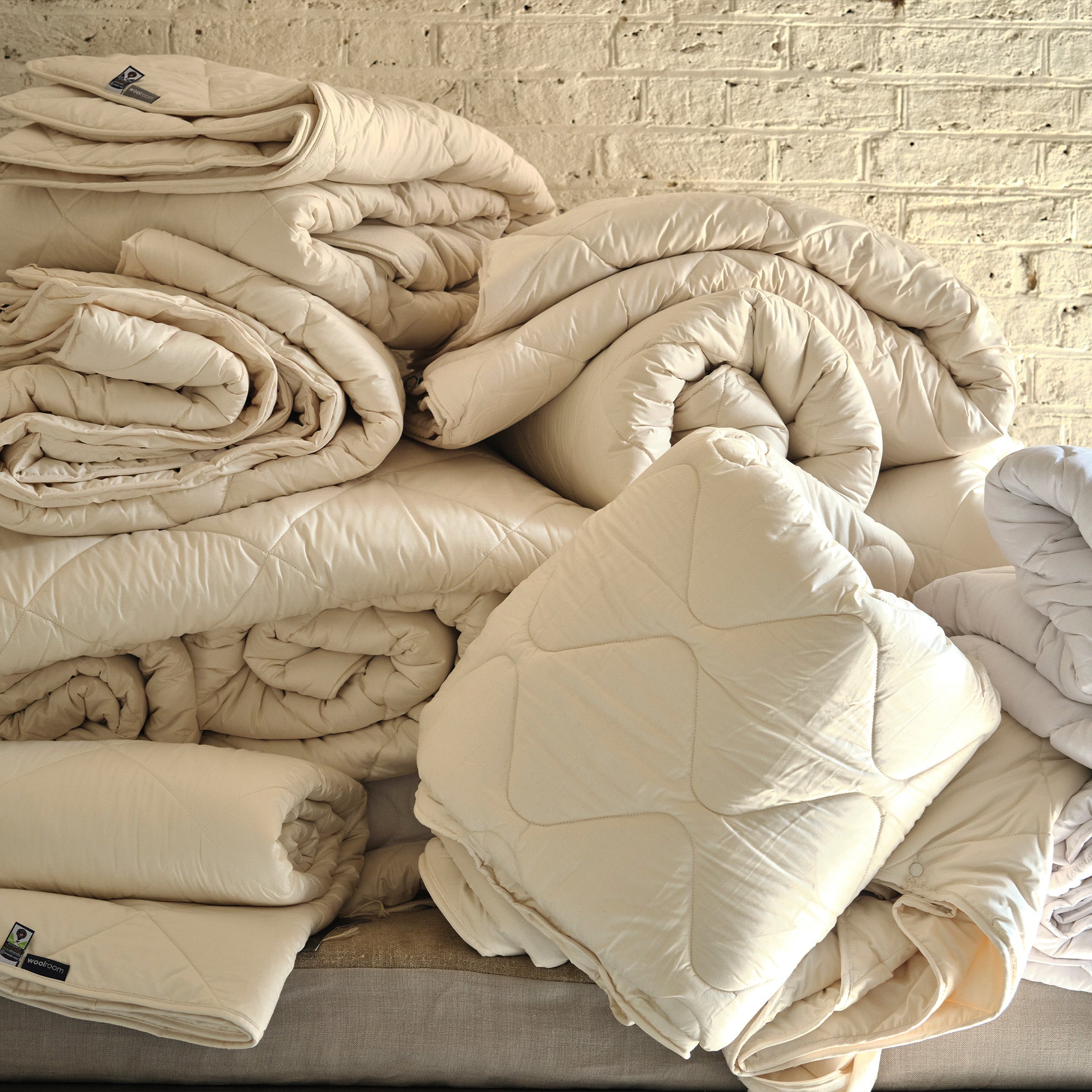 pile of woolroom bedding stacked against a brick wall