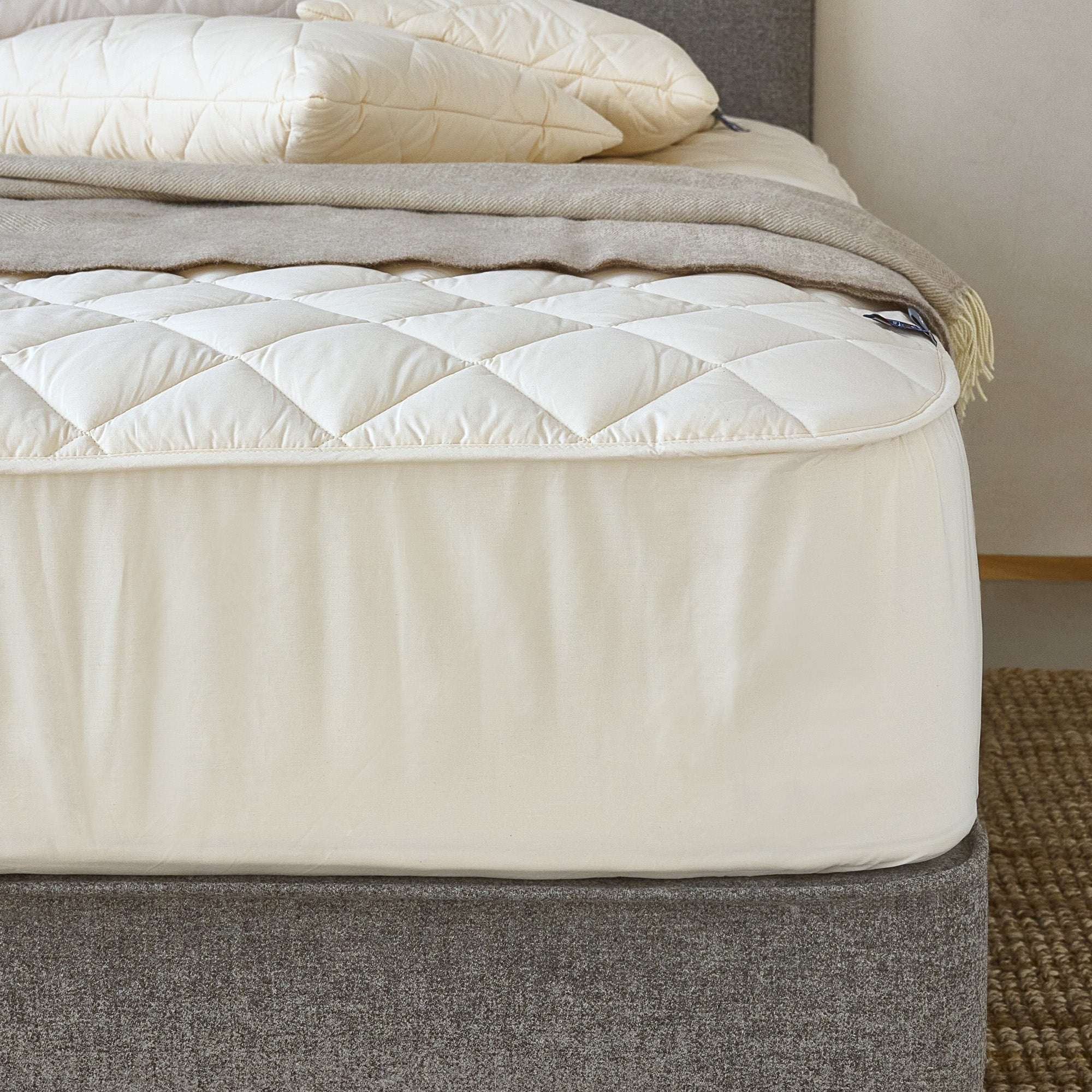 Corner of woolroom mattress with wool protector applied over it