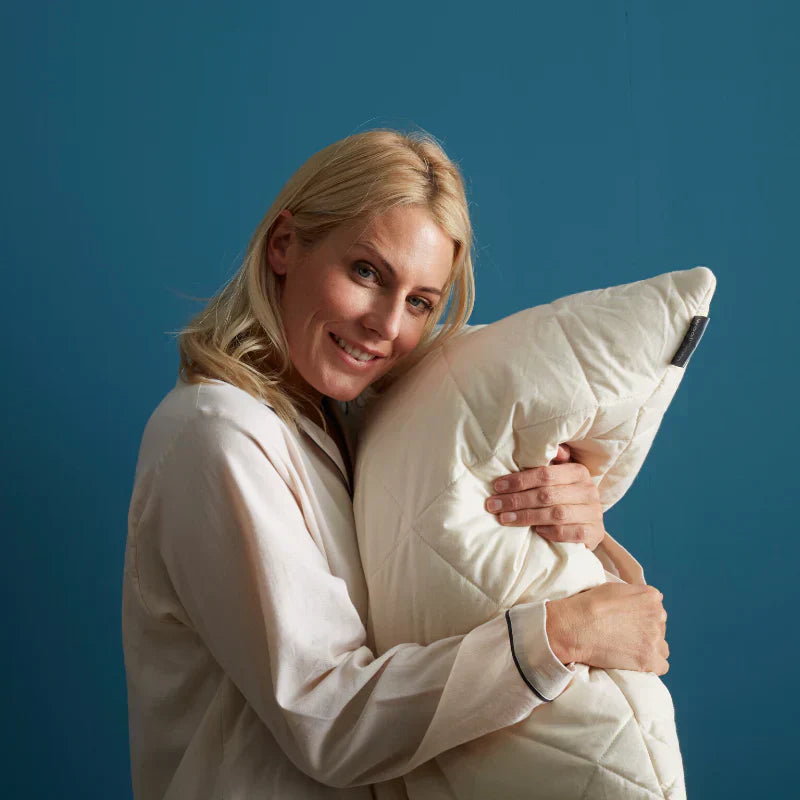 How To Stop Dust Mites Irritating Your Allergies - Lady hugging woolroom pillow