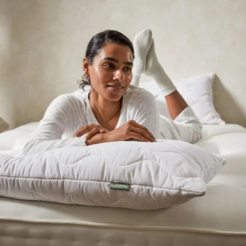 Lady all in white laying on a woolroom Mattress