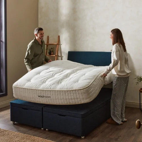 couple placing mattress onto the bed