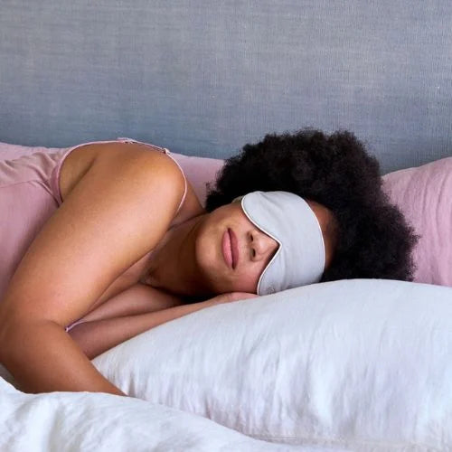 woman lying down with a merino eye mask on
