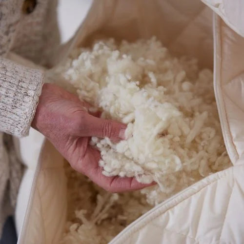 Hand going into a woolroom pilling showing the natural wool