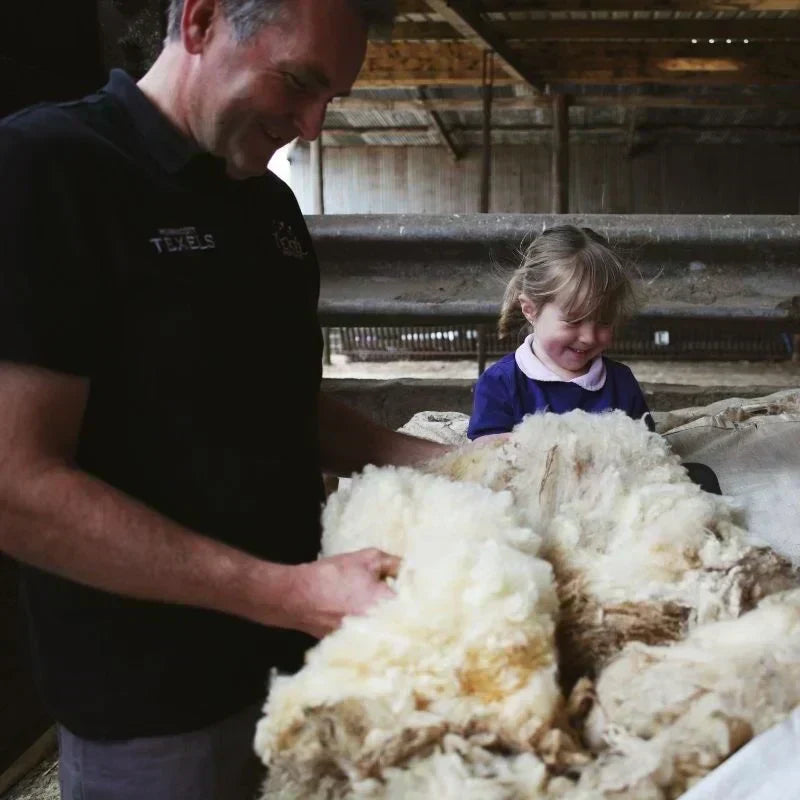 Father and daughter playing with wool