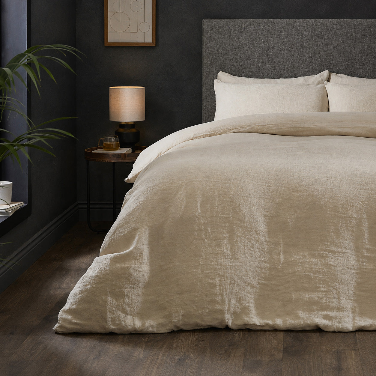 A dressed bed with Woolroom's Mariana Linen Duvet Cover in Sand has the duvet turned down and two pillows. 