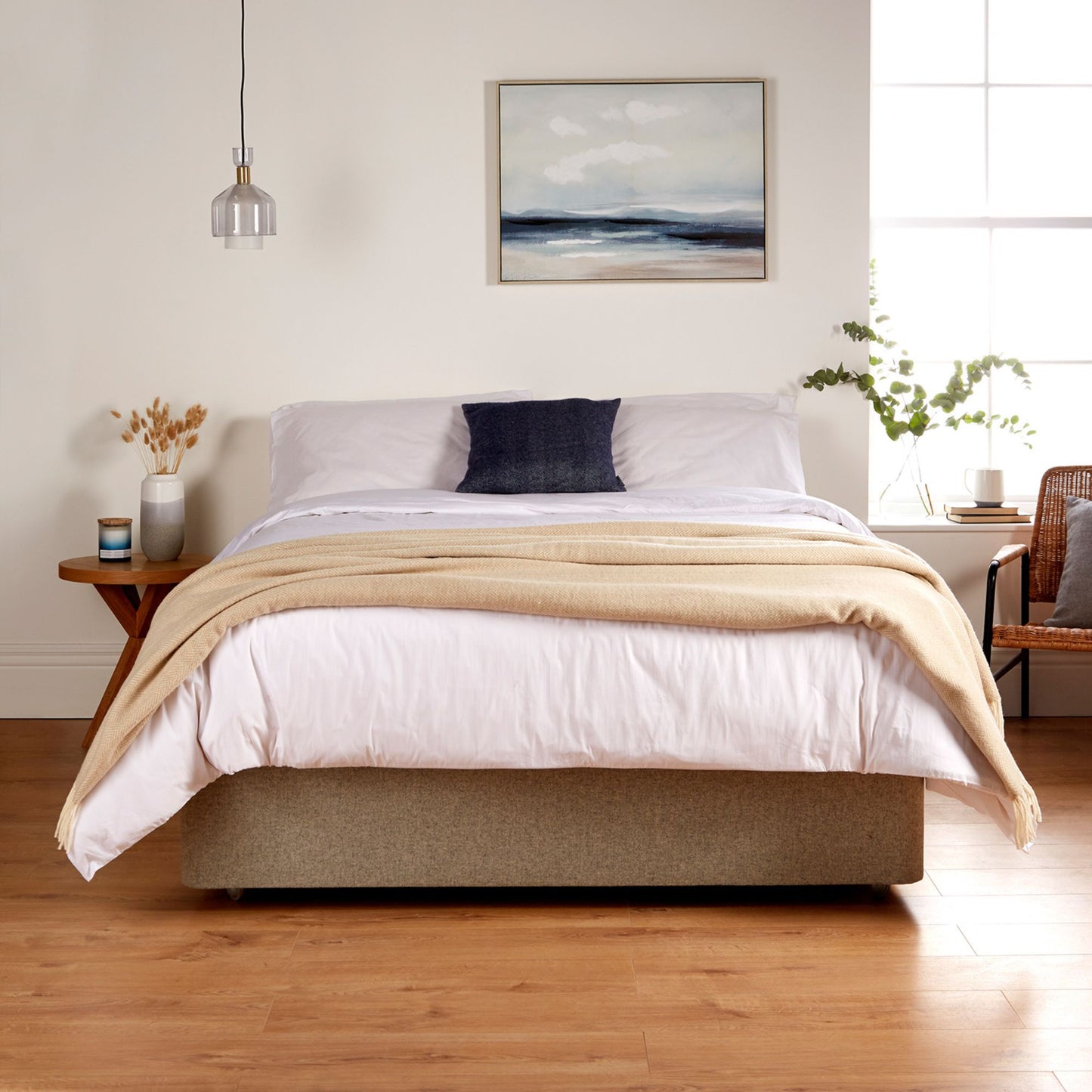 A bedroom showing the Woolroom Chianti Wide Throw in colour Sandstone draped across the foot of the bed.