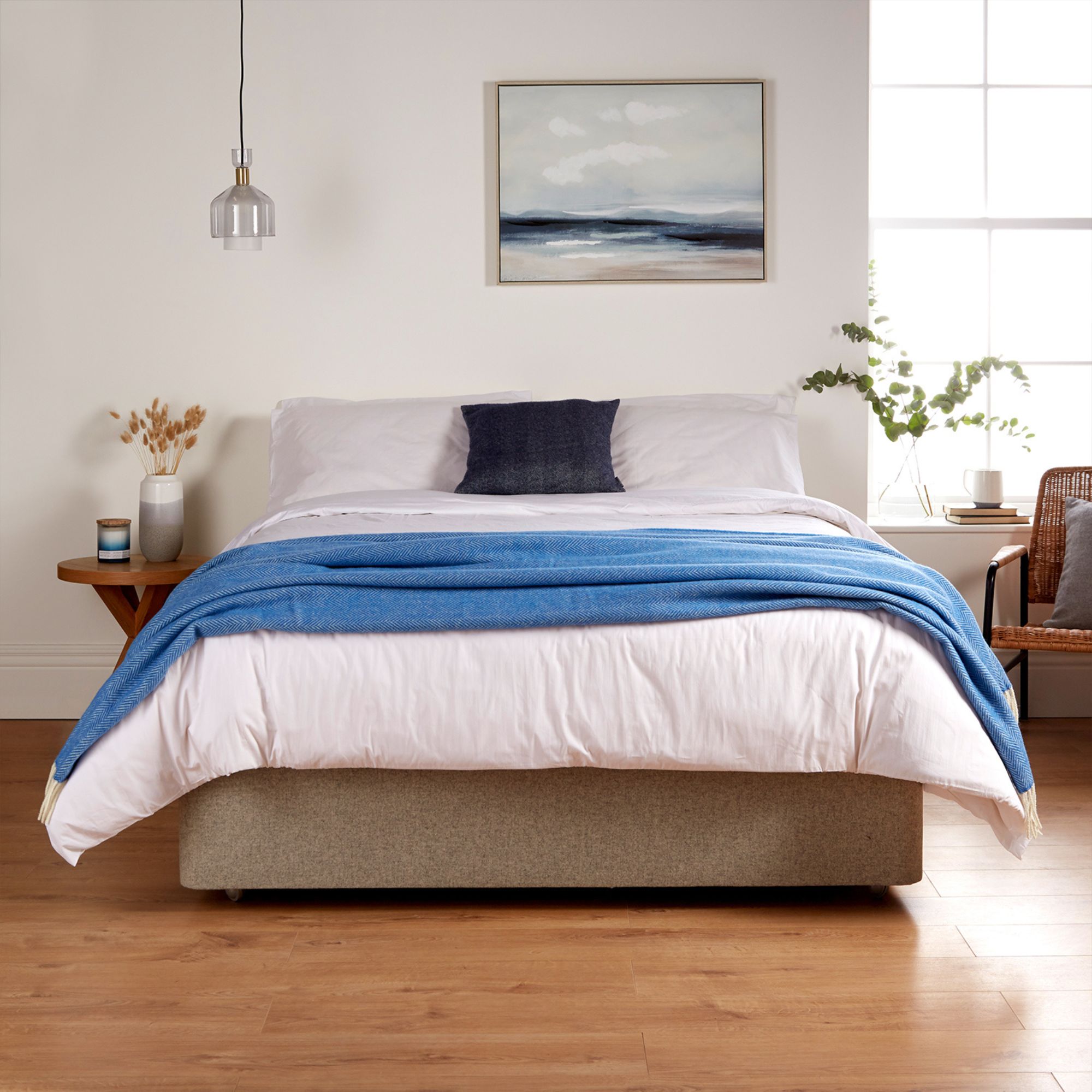A bedroom showing the Woolroom Chianti Wide Throw in colour Azure Blue draped across the foot of the bed.