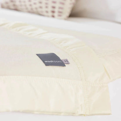 The Woolroom Wharfedale Lambswool Bed Blanket in the colour Pearl is a soft 100% lambswool with a satin edge. 