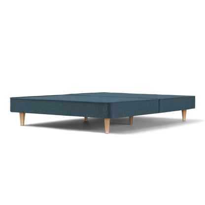 The Woolroom Audley Upholstered Divan with wooden legs in the colour Hemlock, which is a blue upholstery.
