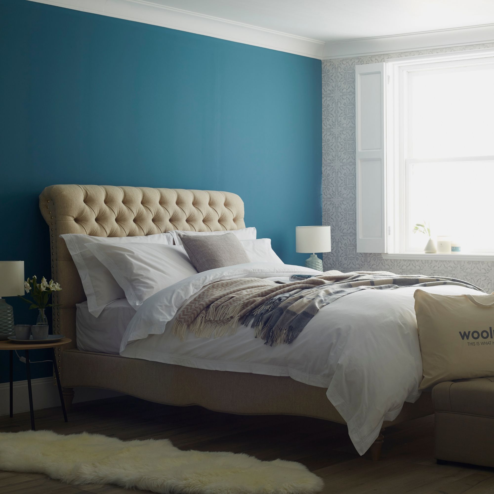 The buttoned Sophia Upholstered Bedstead in a fully custom fabric combination, dressed with a Woolroom white duvet set.