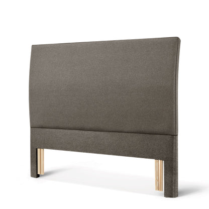 The Woolroom Coleton Floor Standing Headboard in dark grey upholstery has a soft curve and is 100% British wool. 