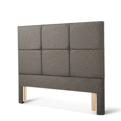 The Woolroom Goddards Floor Standing Headboard in Dark Grey has upholstered panels and can be added seamlessly to a bed.