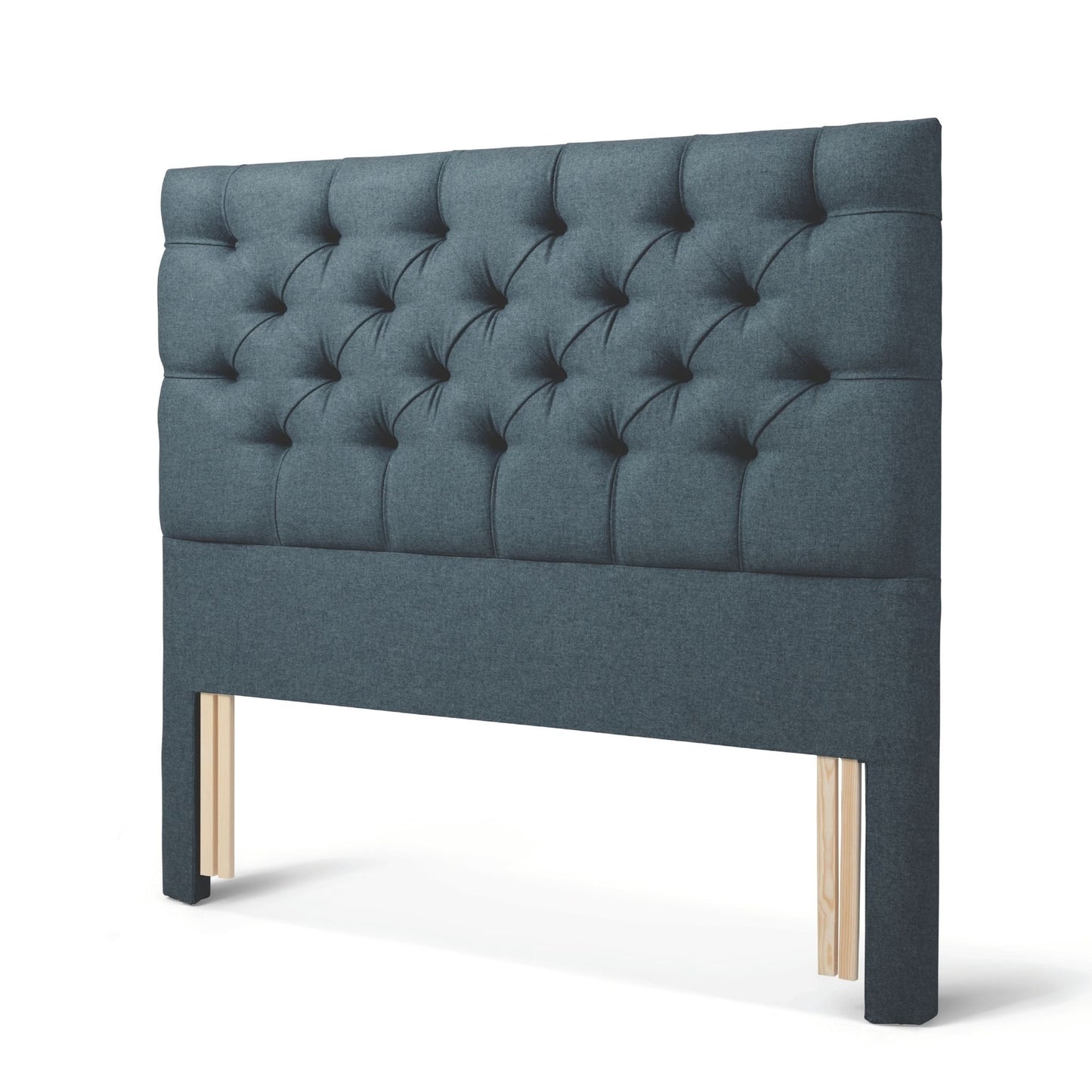 The Woolroom Nuffield Floor Standing Headboard in Hemlock blue has a traditional British buttoning for a tufted design.