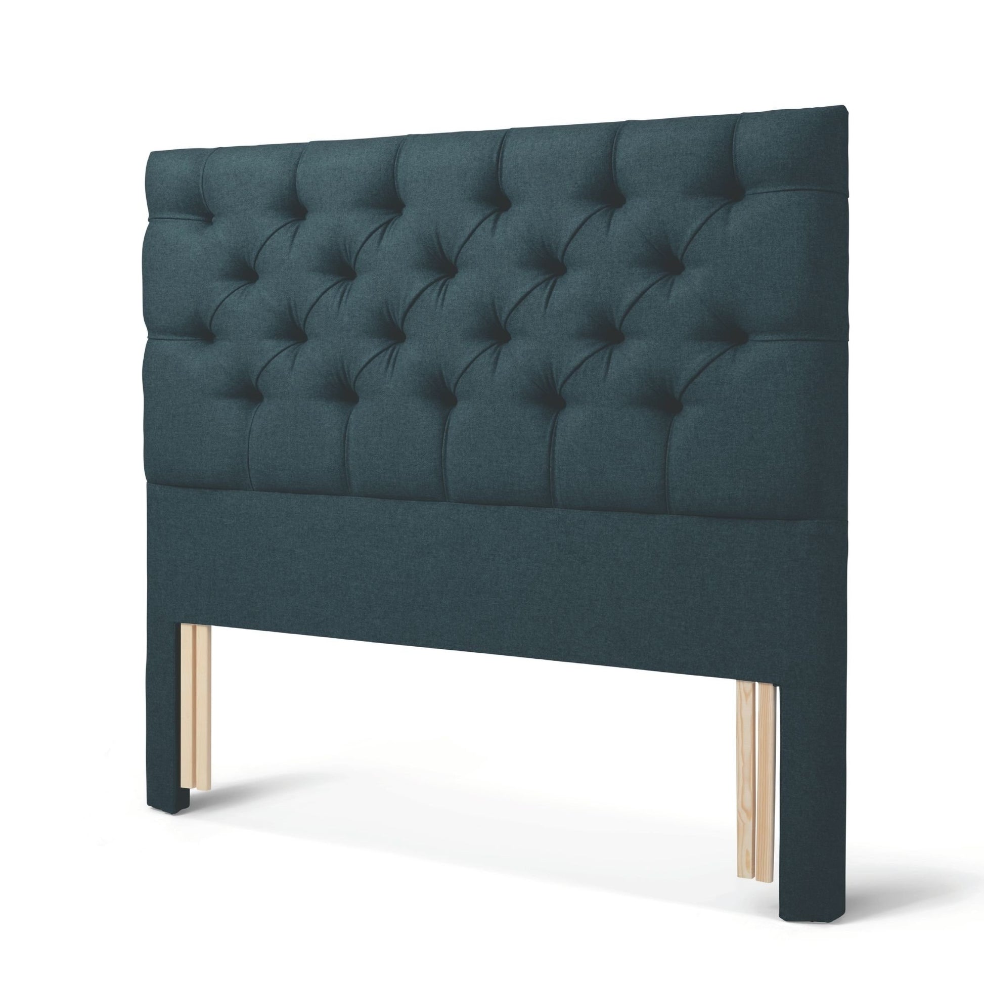 The Woolroom Nuffield Floor Standing Headboard in Pine dark green has a traditional British buttoning for a tufted design.
