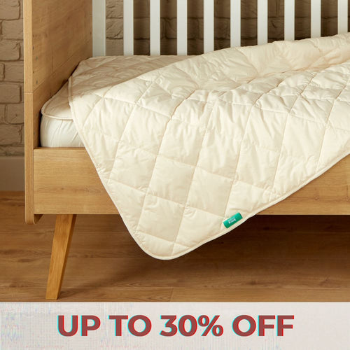 Image of a green Woolroom kids label sewn into the edge of a kids pillow