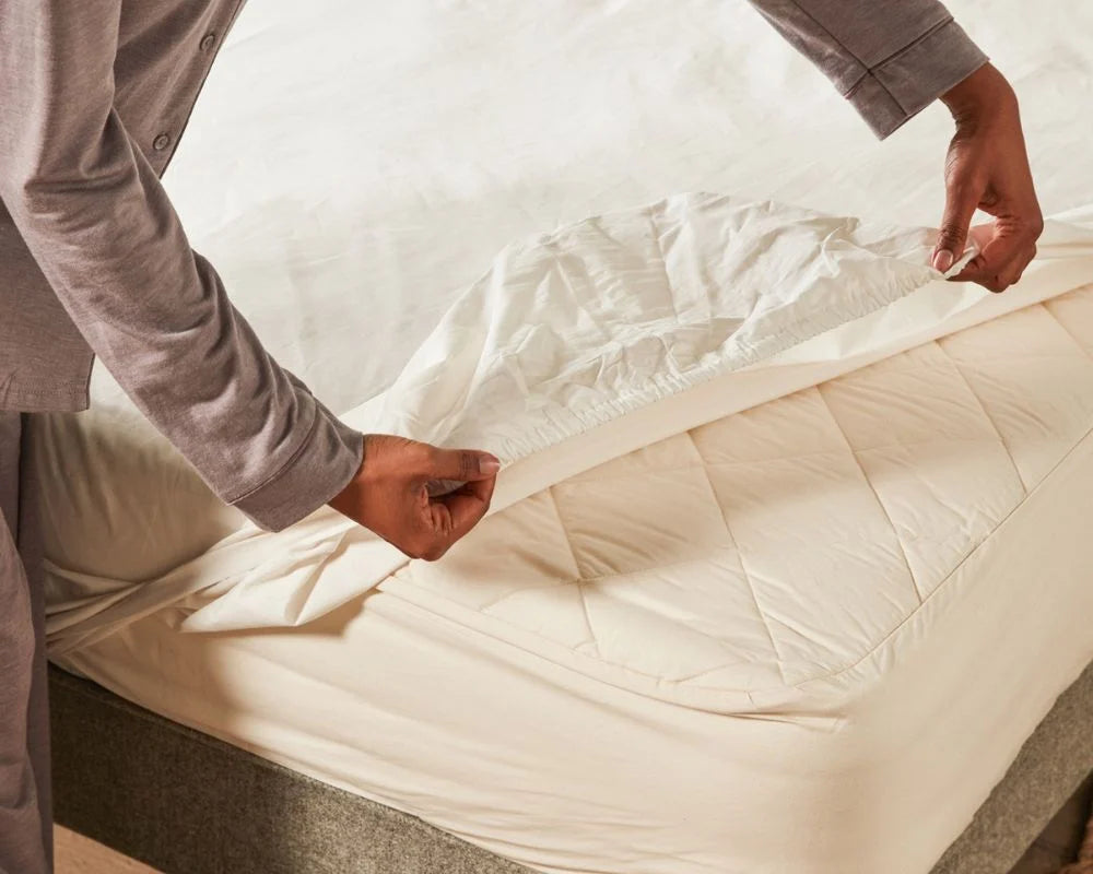 person putting on fitted sheet
