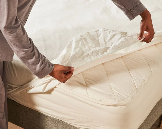 person putting on fitted sheet