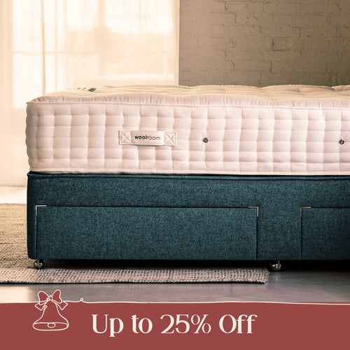 A man hand teasing wool on top of a mattress, in Woolroom's factory