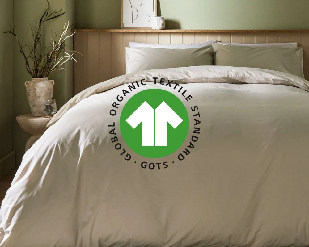 Beige comforter with Global Organic Textile Standard logo on a bed in a bedroom setting.