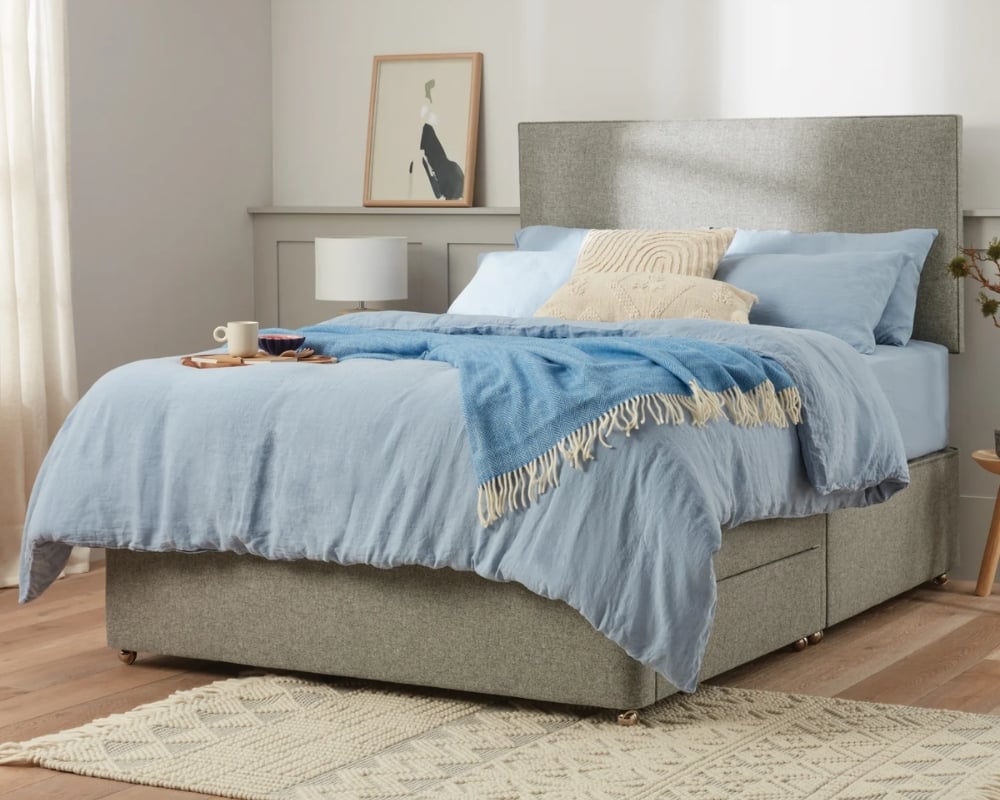 Bedroom with a bed featuring blue bedding and a gray headboard.