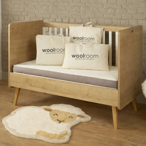 Image of a green Woolroom kids label sewn into the edge of a kids pillow