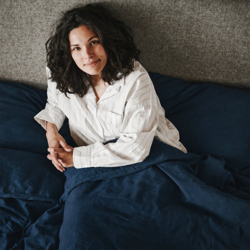 woman in navy blue linen bed