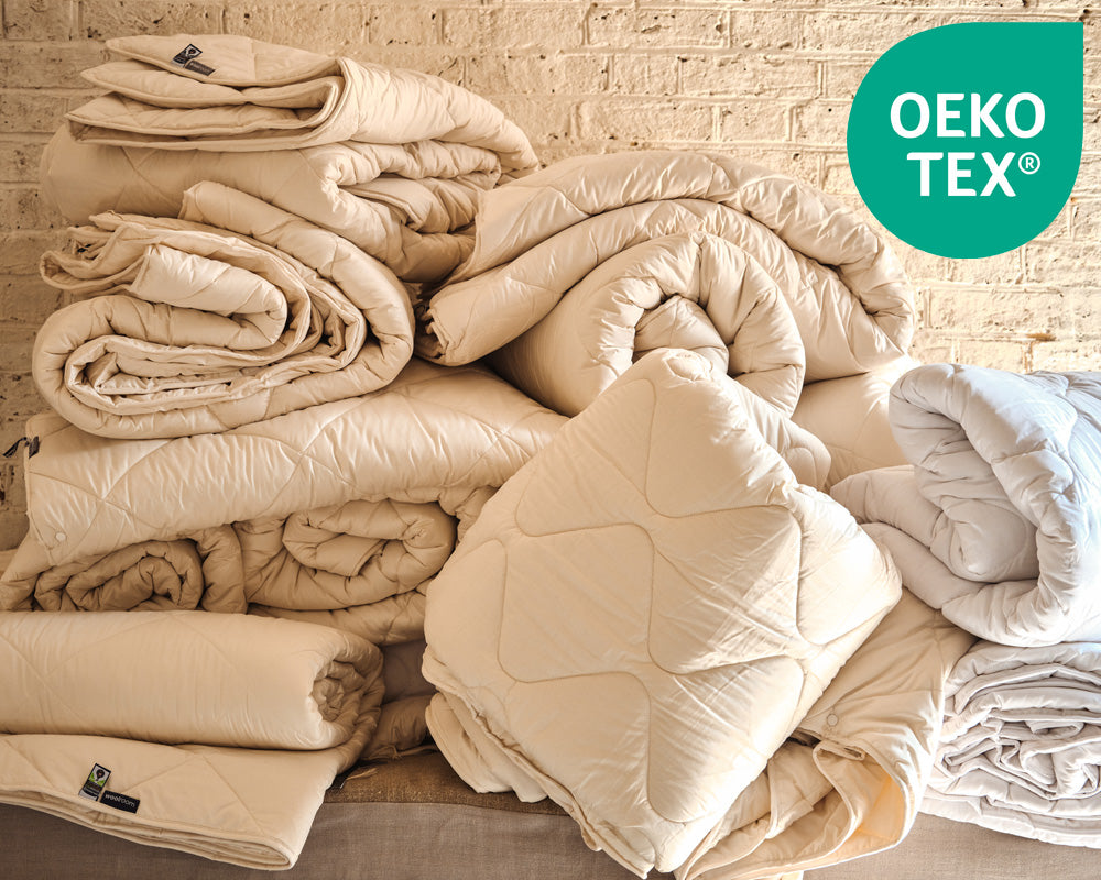 Stack of white pillows on a shelf with OEKO-TEX logo in the corner