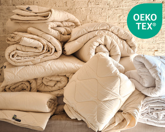 Stack of white pillows on a shelf with OEKO-TEX logo in the corner