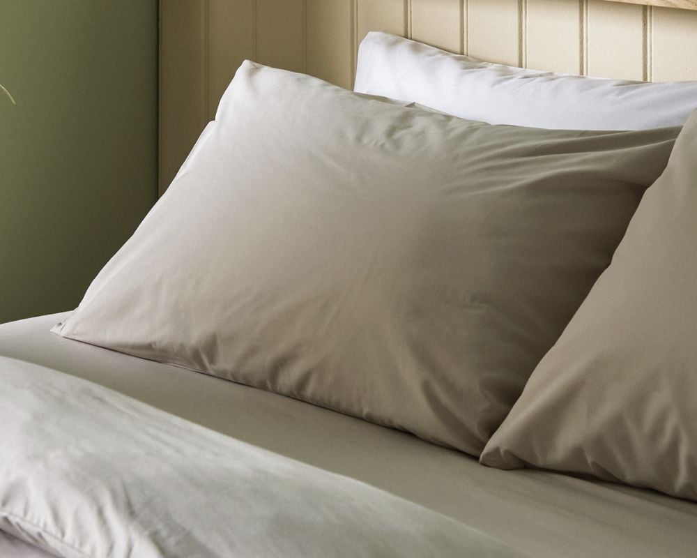 Beige pillows on a bed with a neutral headboard