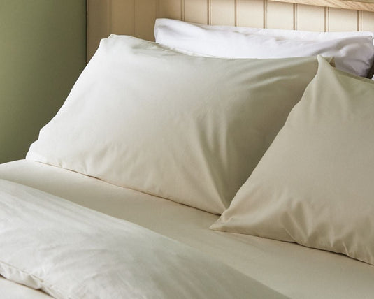 Beige pillows on a bed with a neutral background
