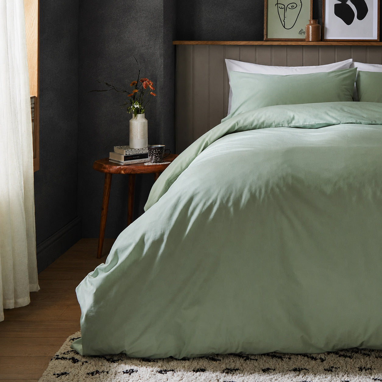 A dressed bed with Arinta Organic Cotton Comforter Cover in Pistachio has the comforter turned down and two pillows.