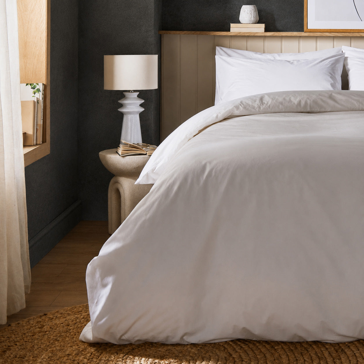 A dressed bed with Arinta Organic Cotton Comforter Cover in White has the comforter turned down and two pillows.