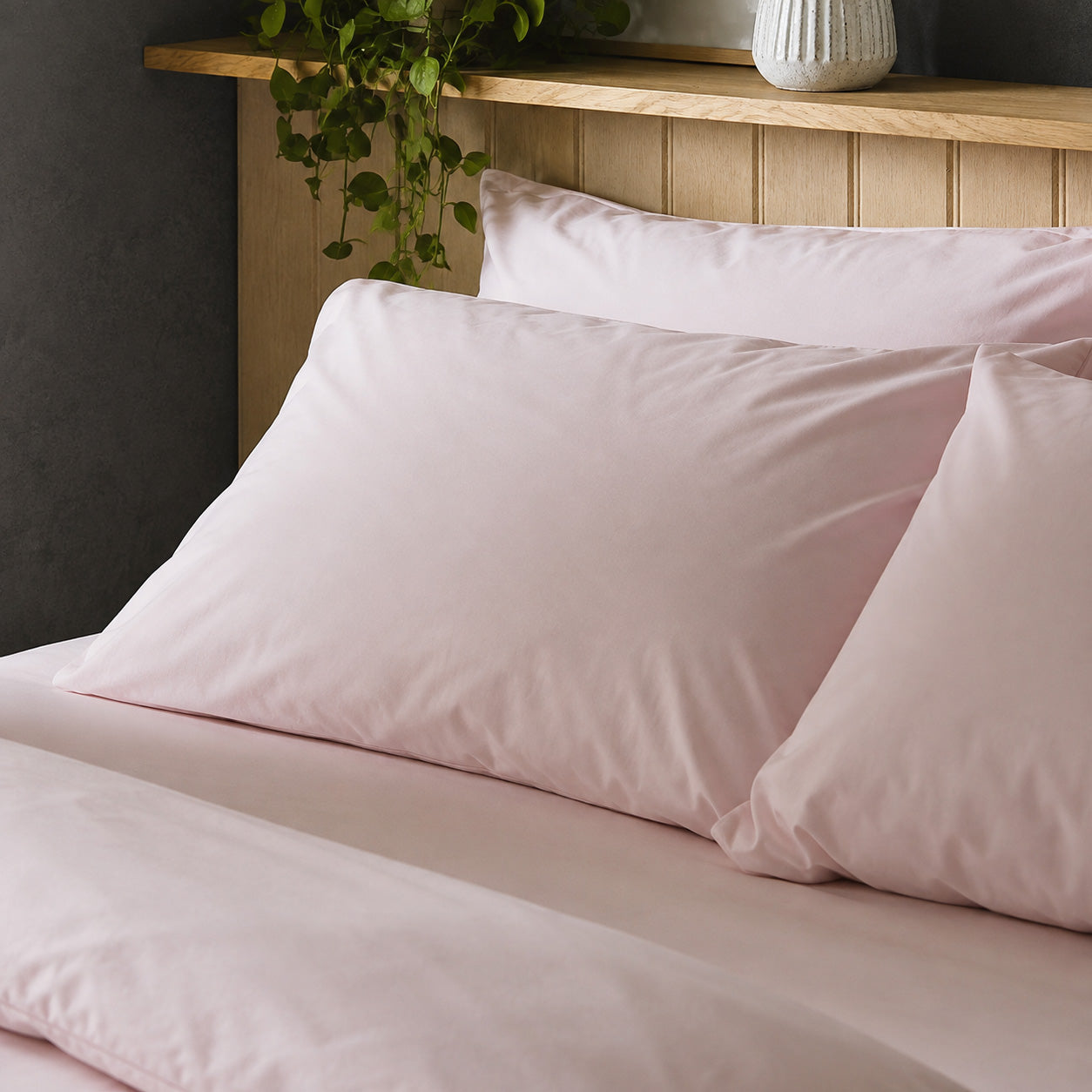 The crisp Arinta Organic Cotton Pillow Case in Marshmallow on a dressed bed with four pillows.