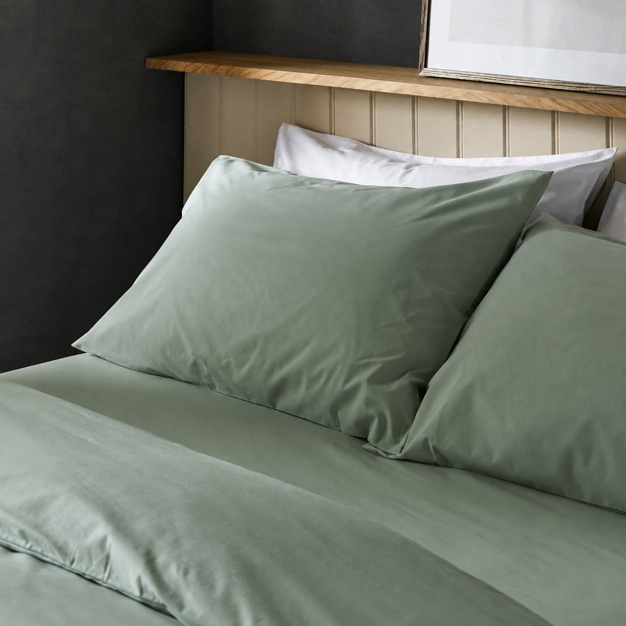 The crisp Arinta Organic Cotton Pillow Case in Pistachio on a dressed bed with four pillows.