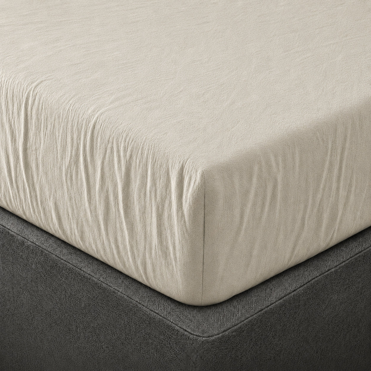 A close up of the corner of a mattress with Woolroom's Mariana Linen Blend Fitted Sheet in Pebble.