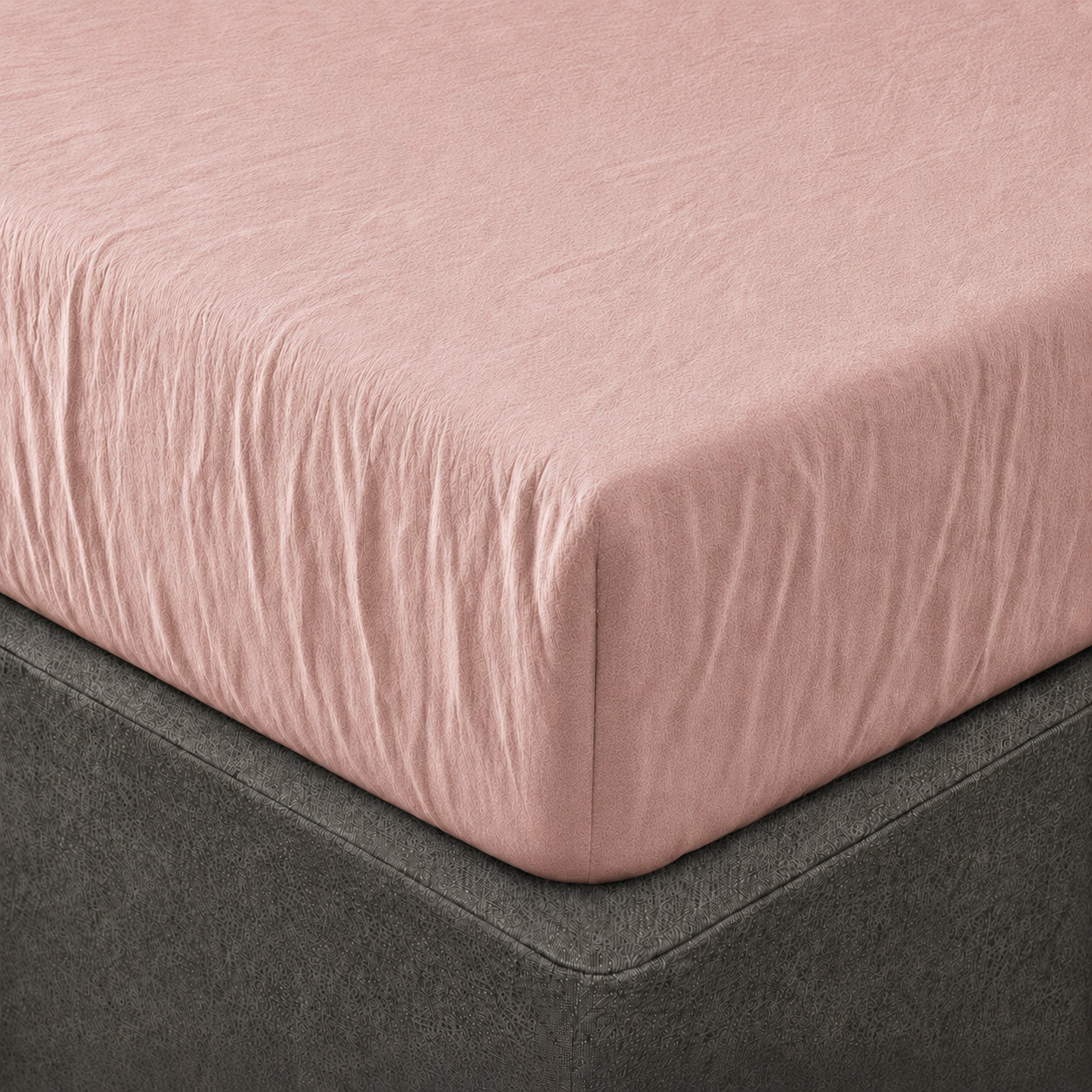 A close up of the corner of a mattress with Woolroom's Mariana Linen Blend Fitted Sheet in Rose.